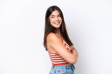 Beyaz arka planda izole edilmiş genç Brezilyalı kadın yana bakıyor ve gülümsüyor.