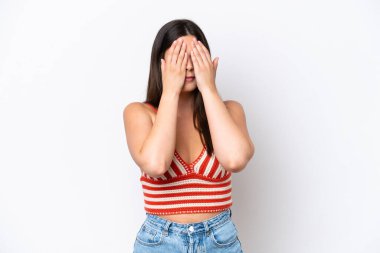 Genç Brezilyalı bir kadın beyaz arka planda izole edilmiş, gözleri elle kaplanmış.
