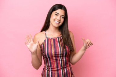 Pembe arka planda izole edilmiş genç Brezilyalı kadın parmakları olan altı kişi saydım.