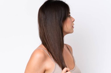 Beyaz arka planda izole edilmiş genç Brezilyalı kadın saçlarına dokunuyor. Portreyi kapat