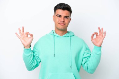 Beyaz arka planda Zen pozisyonunda beyaz tenli yakışıklı bir adam.