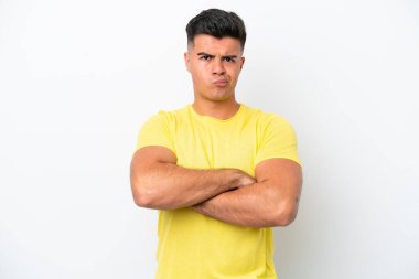 Beyaz arka planda, mutsuz bir ifadeyle soyutlanmış beyaz, beyaz, yakışıklı bir adam.