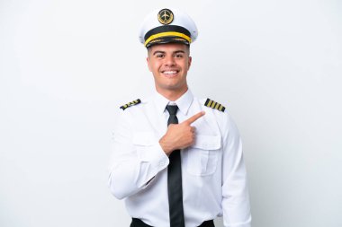 Airplane pilot caucasian man isolated on white background pointing to the side to present a product