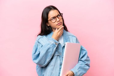 Pembe arka planda izole edilmiş genç Kolombiyalı kadının şüpheleri var.