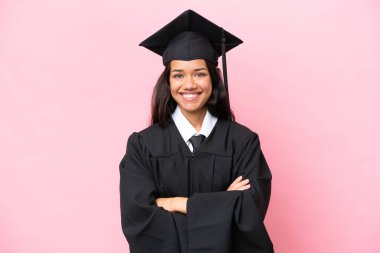 Young university Colombian woman graduate isolated on pink background keeping the arms crossed in frontal position