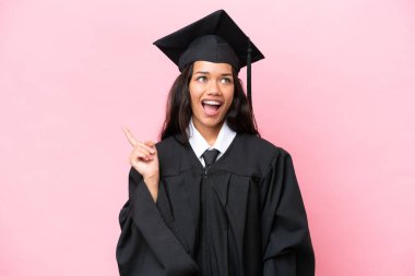 Young university Colombian woman graduate isolated on pink background thinking an idea pointing the finger up
