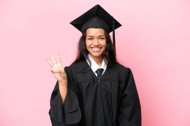 Young university Colombian woman graduate isolated on pink background happy and counting three with fingers