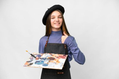 Young artist man holding a palette over isolated white background giving a thumbs up gesture