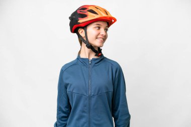 Teenager cyclist girl over isolated white background looking side
