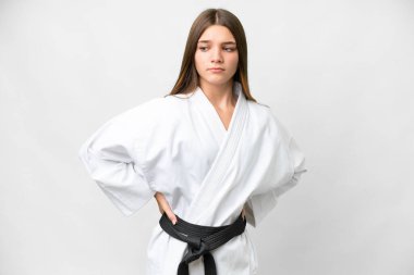 Teenager girl doing karate over isolated white background suffering from backache for having made an effort