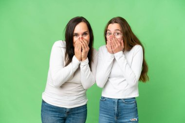 mother and daughter over isolated chroma key background with surprise facial expression