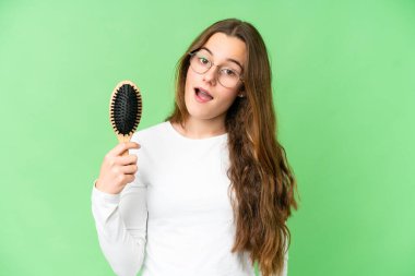 Teenager girl with hair comb over isolated chroma key background with surprise and shocked facial expression