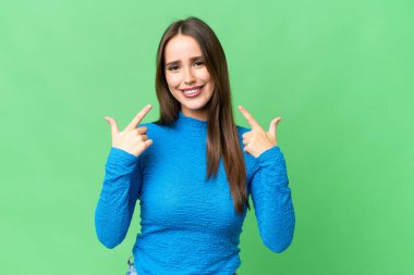 Young beautiful woman over isolated chroma key background giving a thumbs up gesture