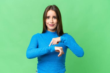 Young beautiful woman over isolated chroma key background making the gesture of being late