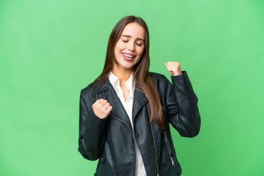 Young beautiful woman over isolated chroma key background celebrating a victory