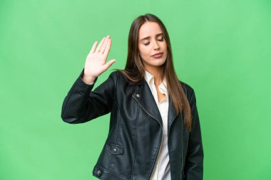 Young beautiful woman over isolated chroma key background making stop gesture and disappointed