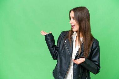 Young beautiful woman over isolated chroma key background with surprise expression while looking side