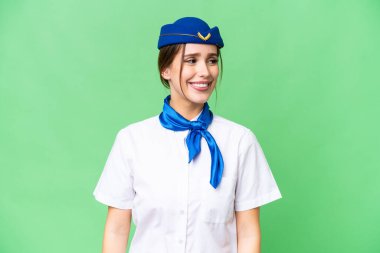Airplane stewardess over isolated chroma key background looking side