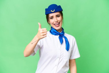 Airplane stewardess over isolated chroma key background with thumbs up because something good has happened