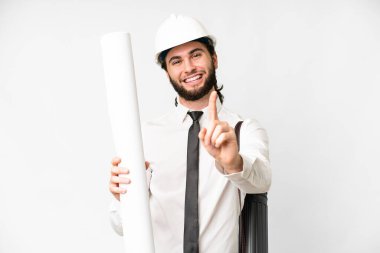 Miğferli genç bir mimar, izole edilmiş beyaz arka plan üzerinde planlar tutuyor ve parmağını kaldırıyor.