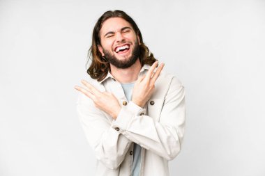 Genç yakışıklı adam izole edilmiş beyaz arka planda gülümsüyor ve zafer işareti gösteriyor.