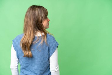 Arka planda izole edilmiş krom anahtar arka planda ve yan görünümlü genç kız