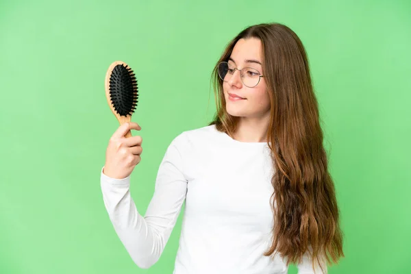 Teenager girl with hair comb over isolated chroma key background with happy expression