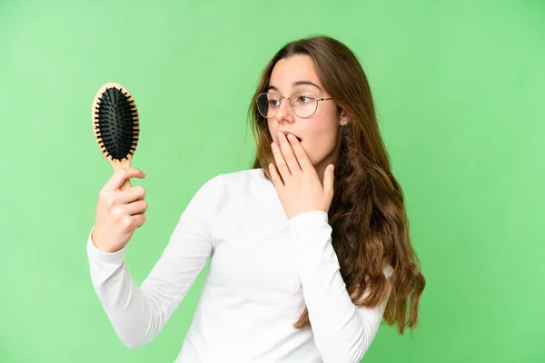 Teenager girl with hair comb over isolated chroma key background with surprise and shocked facial expression