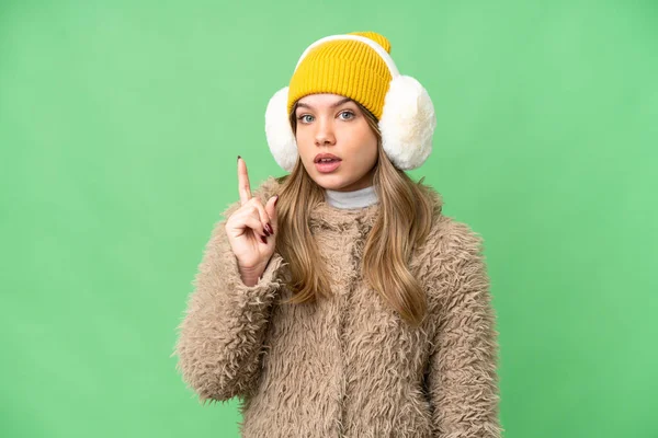 年轻姑娘披着冬衣 背对着孤立的彩色关键背景 想着指指点点的办法 — 图库照片