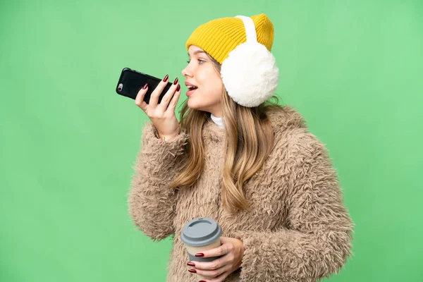 Junges Mädchen Trägt Wintermuffs Über Isoliertem Chroma Schlüsselhintergrund Mit Kaffee — Stockfoto