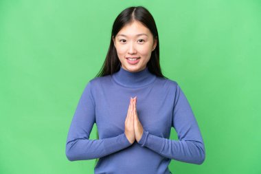 Tecrit edilmiş krom anahtar geçmişi olan genç bir Asyalı kadın avuç içlerini bir arada tutuyor. İnsan bir şey ister.