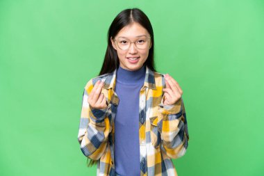 Soyutlanmış krom anahtar geçmişi olan genç Asyalı kadın para hareketi yapıyor.