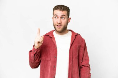 Genç, sarışın, soyutlanmış beyaz arka planda bir parmağını kaldırarak çözümü bulmaya çalışan bir adam.