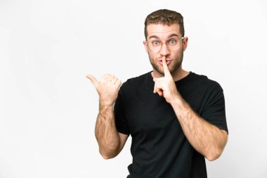 Yakışıklı sarışın, soyutlanmış beyaz arka planda genç bir adam. Yan tarafı gösteriyor ve sessiz hareketler yapıyor.