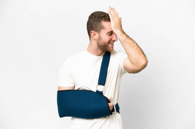 Kırık kollu yakışıklı sarışın bir adam ve izole edilmiş beyaz bir arkaplanda askı takan bir adam bir şeyin farkına vardı ve çözüme niyetlendi.