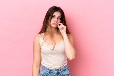 Pembe arka planda izole edilmiş beyaz bir kadın sessizlik işareti gösteriyor.