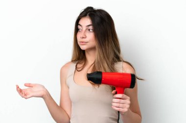 Young caucasian woman holding a hairdryer isolated on white background with surprise facial expression