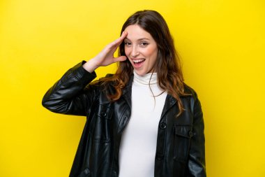 Sarı arka planda izole genç beyaz kadın bir şey fark etti ve çözüme niyetlendi.