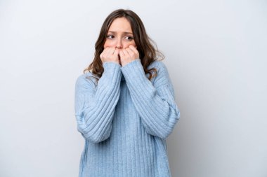 Beyaz arka planda izole edilmiş genç beyaz bir kadın gergin ve korkmuş bir şekilde elleriyle suni teneffüs yapıyor.