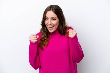 Beyaz arka planda izole edilmiş genç beyaz kadın galibiyeti kutluyor.