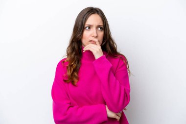 Beyaz arka planda izole edilmiş genç beyaz bir kadın. Şüpheleri var ve kafası karışmış bir yüz ifadesi var.