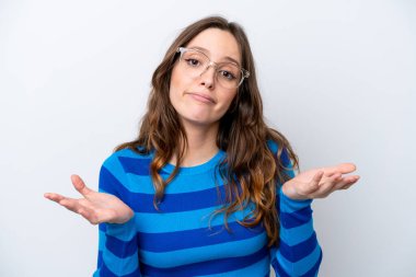 Beyaz arka planda gözlüklü ve kuşkuları olan beyaz tenli genç bir kadın.