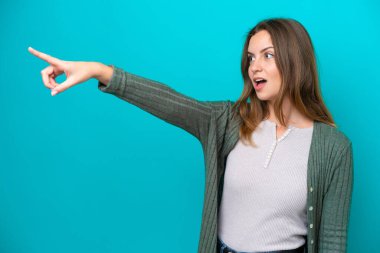 Mavi arka planda izole edilmiş genç beyaz kadın...