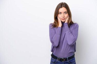 Beyaz arka planda izole edilmiş genç beyaz kadın hayal kırıklığına uğramış ve kulaklarını kapatmış.