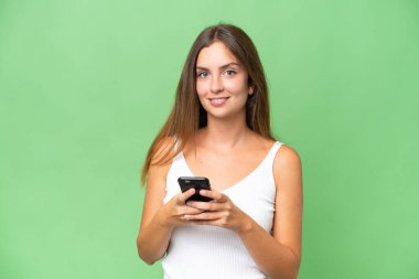 Tecrit edilmiş genç ve güzel bir kadın cep telefonuyla mesaj gönderiyor.