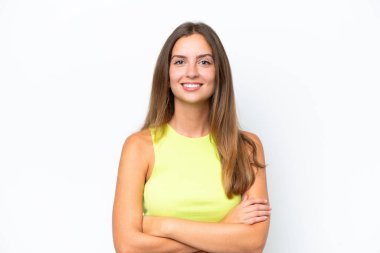 Beyaz arka planda izole edilmiş genç beyaz kadın kollarını ön cephede çapraz tutuyor.