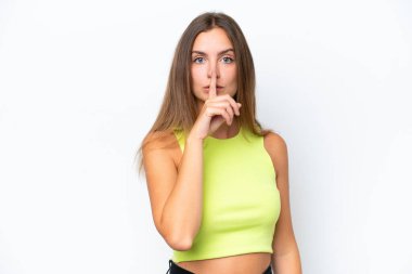 Beyaz arka planda izole edilmiş beyaz bir kadın sessiz bir jest işareti gösteriyor. Parmağını ağzına sokuyor.