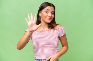 Young caucasian woman isolated on green chroma background counting five with fingers clipart