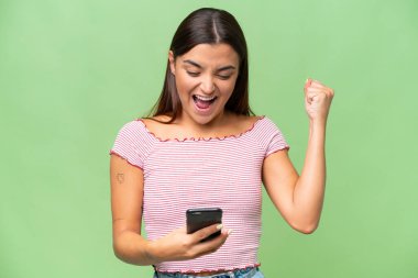 Young caucasian woman isolated on green chroma background surprised and sending a message