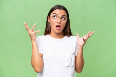 Young caucasian woman isolated on green chroma background stressed overwhelmed